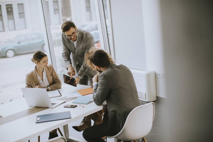 Group of young business people working and communicating while s